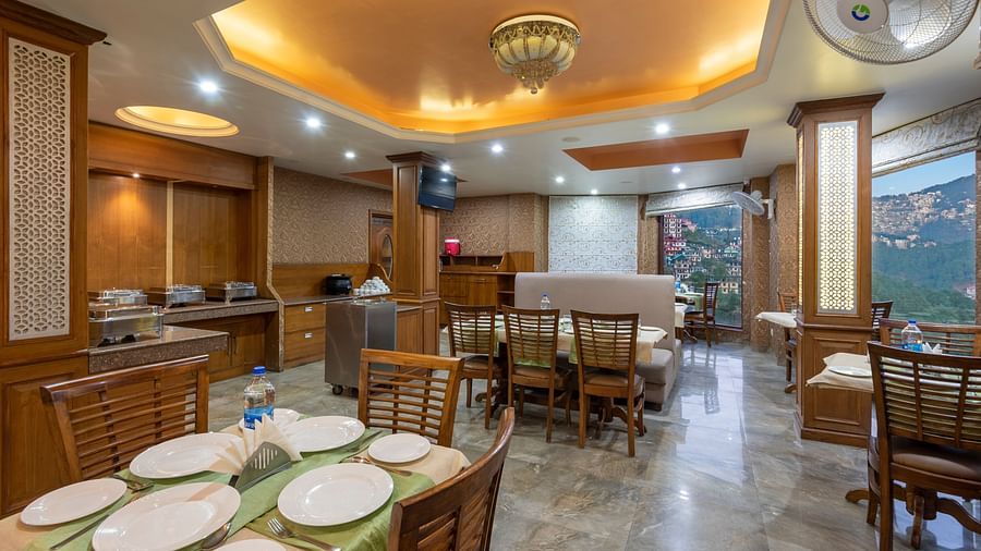 Dining area with a table set for a meal, featuring chairs and plates neatly arranged on the table at DLS Hotels The Rock Castle.